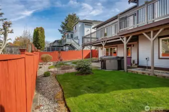 Fully fenced backyard with firepit, hot tub, garden shed, covered patio and upper deck