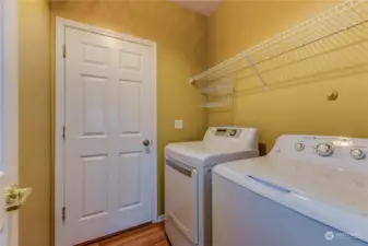 Utility room on the main floor and the door leads to the garage. The washer and dryer stay with the home.