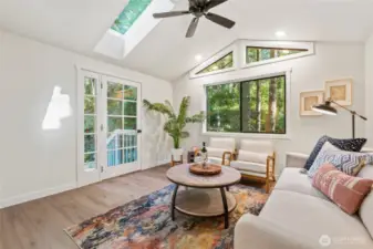 Lovely family room with skylights, french doors to back deck and abundant windows looking out at the lush landscaping!