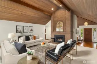 Light and bright living room with vaulted wood ceilings and gas fireplace. Home is not currently staged