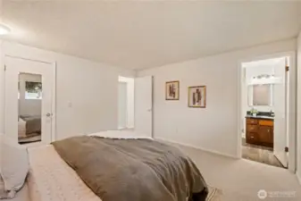 Primary bedroom with walk-in closet on left, and private bathroom on right.