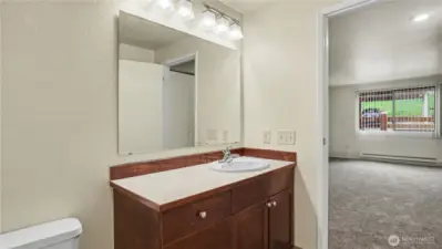 Centrally located full bath with more of the sleek countertops and warm cabinetry.