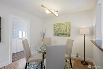 Formal dining room is anchored with branching globe pendant. To the left, the ¾ bath helps keep guest traffic on this floor.