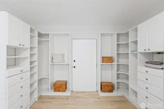 The walk-in delivers: full custom organization system, floor to ceiling, with a deadbolted door to the exterior storage room beyond.