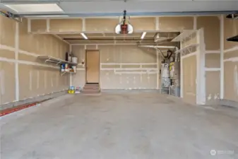 Spacious garage with shelving. Offers 220V outlet.