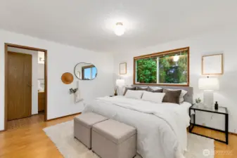 A view of the primary bedroom showing the pocket door that goes to the full bath.