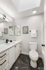 Full/guest bath showcasing the New tiled floor and  skylight opening above!