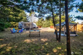 Camp with ease on this cleared lot offering full RV hookups and a gravel base. Surrounded by trees and fencing for a peaceful, private experience.