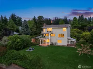 Dusk shot looking at part of the backyard. Large flat grassy lawn for dogs or kiddos. Great little firepit area.