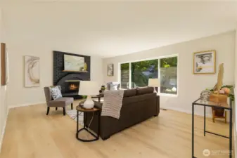 The living room is bright and warm with a wood burning fireplace and huge, sunny windows.