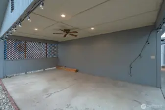 Covered patio has ceiling fan and lights.