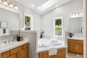 Primary bath featuring white tile counters with two sinks and jacuzzi tub