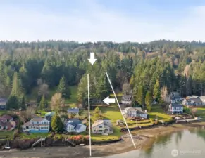 Three separate structures anchor this rare no-bank waterfront property with sweeping Puget Sound views. The arrow highlights the detached ADU, while the upper arrow indicates the detached garage/shop, illustrating the property’s flexible, multi-structure layout.