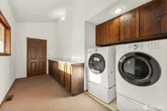 Spacious utility room with front-load washer and dryer and direct access to the attached two-car garage.