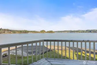 Deck living connects directly to the yard and rare no-bank waterfront.