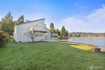 Three structures. No-bank waterfront. Endless potential. Main home, newer ADU, and a high-ceiling garage/shop for RVs or boats—all with water views and beach access on Puget Sound.