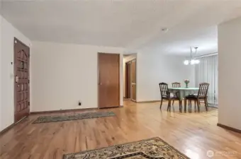 Hardwood flooring extends down hallway and under carpet in bedrooms