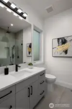 Main floor 3/4 bath with custom tile shower and frameless shower glass.