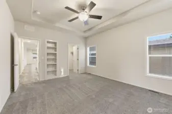 Primary suite features built-in shelving and space for a sitting area or desk, creating a peaceful, personalized retreat.