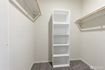 Spacious walk-in closet with built-in shelving and 2 separate hanging areas provides excellent organization and easy access to daily essentials.