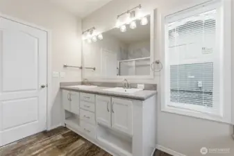 Primary bath features dual vanities, abundant storage, and elegant finishes for a clean, modern look.