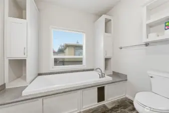 Relax and recharge in the deep soaking tub surrounded by convenient side shelving and natural light.
