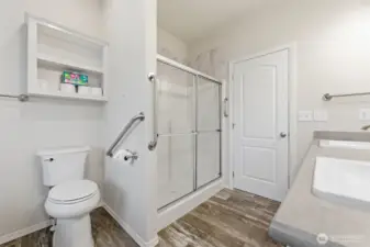 Walk-in shower with glass doors and a comfort-height toilet ensures ease, safety, and modern accessibility.
