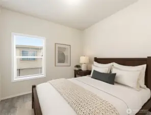 Bright and inviting second bedroom offers a comfortable space for guests or quiet relaxation. (Photo virtually staged)