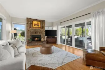Family room right off the kitchen with another fireplace and to the right is a slider to the deck/backyard.