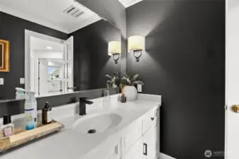 Refreshed powder bath features new paint, hardware and light fixtures.