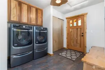Laundry room with Full size Washer and Dryer, Custom Cabinets and Live edge Counter top. Custom Entry Door and trimis outstanding.