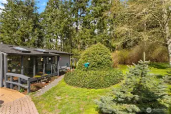 Tranquil home with charming sunroom, skylights, and lush greenery nestled in a private woodland setting.