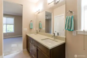 Another view shows double sinks and quartz counter tops.  Private commode.