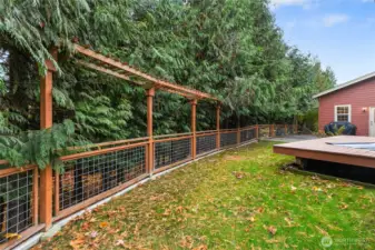 Beautiful arbor fencing surrounds the backyard and from this angle, you can see beyond the fence where a path leads down to the peaceful seasonal creek below.