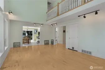 Living room looking into dining/kitchen area plus upstairs balcony.