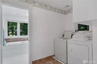 Laundry room with bathroom beyond.