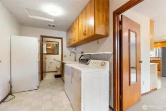 The front entrance into the mud room with washer and dryer and looking into a 1/2 bath.