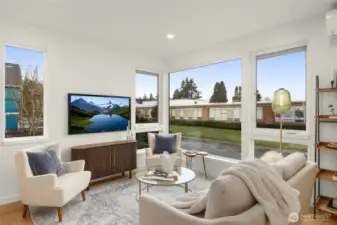 The living room radiates comfort and livability, with wide-plank flooring, modern lighting, and space for both entertaining and relaxing.