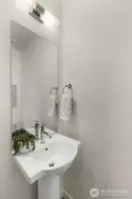 Sleek powder bath thoughtfully designed for guests, combining modern fixtures with a touch of elegance.