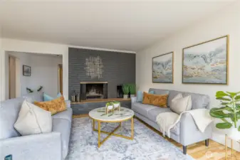 Bright living room features a brick accent wall & wood-burning fireplace