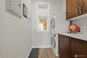 Dedicated laundry room with stacked Bosch washer and dryer, and plenty of storage.