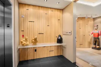 Elevator opens into the private vestibule. Designer ash wood wall with metal set-ins and custom cut-glass attached table.