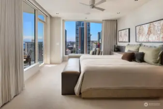 Lush Primary Bedroom Ensuite with wall of windows to capture the breathtaking views. Automatic Lutron Blinds, Blackout Drapes, Private Deck, Ceiling Fan and Sitting Area. WOW!