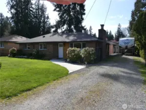 Warm inviting front of home with a deep driveway for RV parking