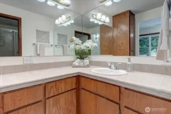 The primary bath offers plenty of wood cabinetry and tile countertops