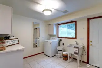 The main level laundry room is huge and includes tile floors, a folding counter, utility sink (perfect for washing your pets or projects) and plenty of storage