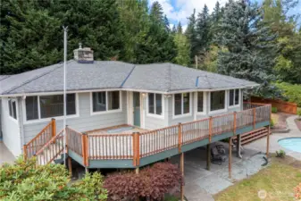 The front porch area and large wrap-around deck leads to the pool and added deck area.