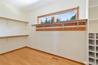 Primary walk-in closet with build-in drawers and shelfs.