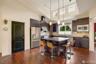 At the heart of the home, the chef’s kitchen features an oversized island with seating, a breakfast nook, wet bar, and seamless connection to the living spaces. The seller plans to leave the bar stools for added convenience.