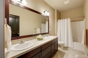 A full bathroom features dual sinks and ample counter space, making busy mornings comfortable and bump-free.